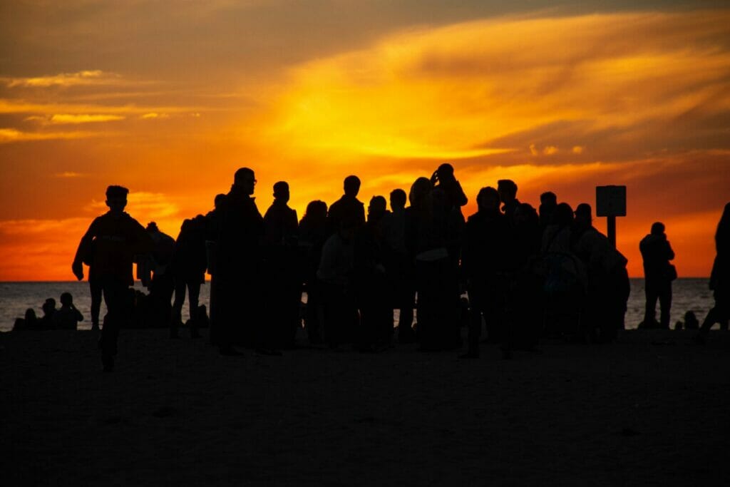 Eine Gruppe junger Leute am Strand bei Sonnenuntergang.