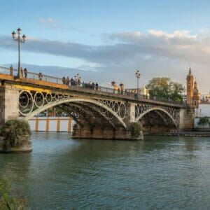 El Puente de Triana es un icónico puente que cruza el río Guadalquivir en Sevilla. Conecta el barrio de Triana, ubicado al oeste del río, con el centro histórico de Sevilla al este