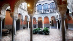 Patio interior con arcos y azulejos en la Casa Palacio Salinas en Sevilla