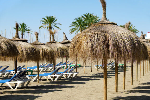 fila-sombrillas-paja-hamacas-playa-marbella-espana_1147-900